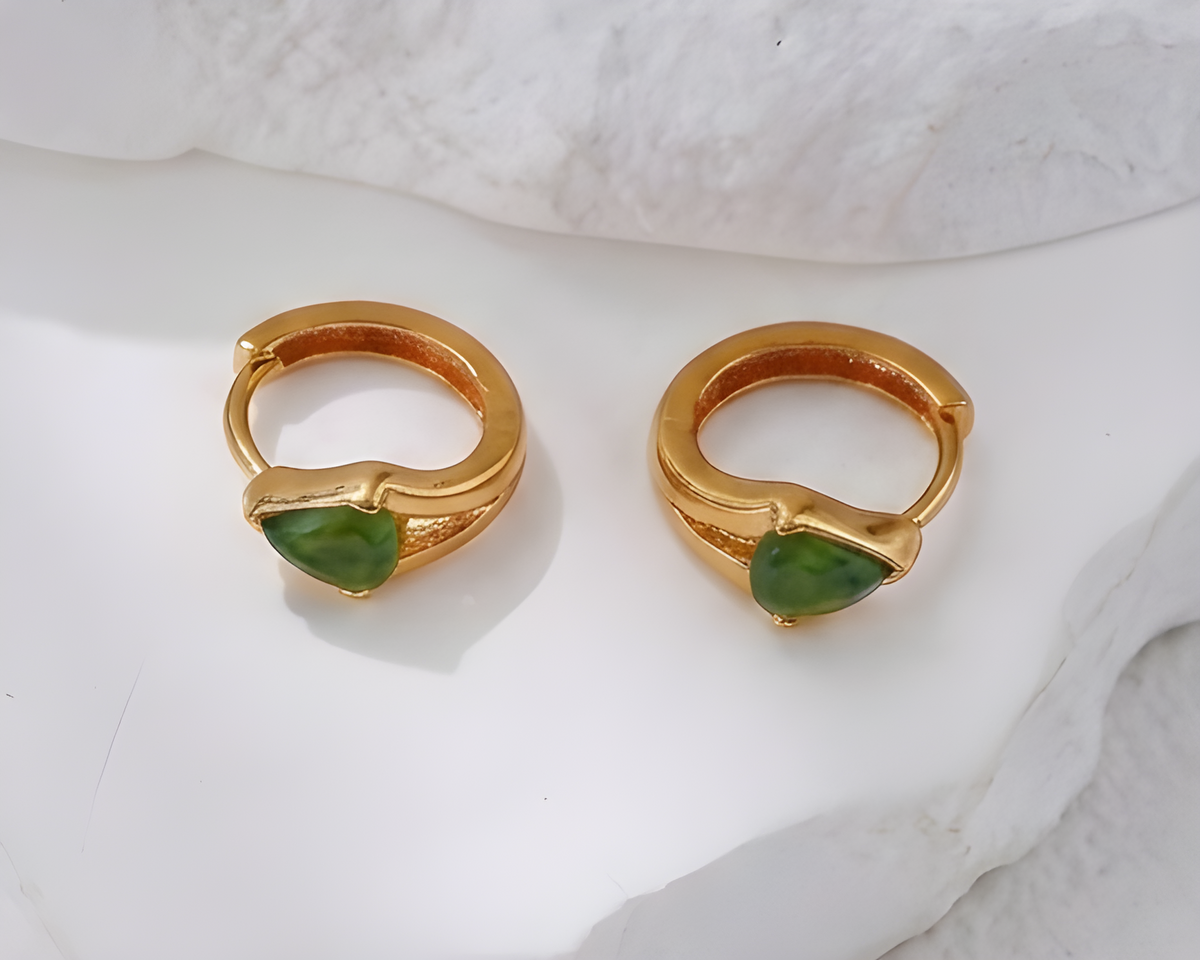 A pair of gold-tone hoop earrings, one set with a green Hotan jade stone
