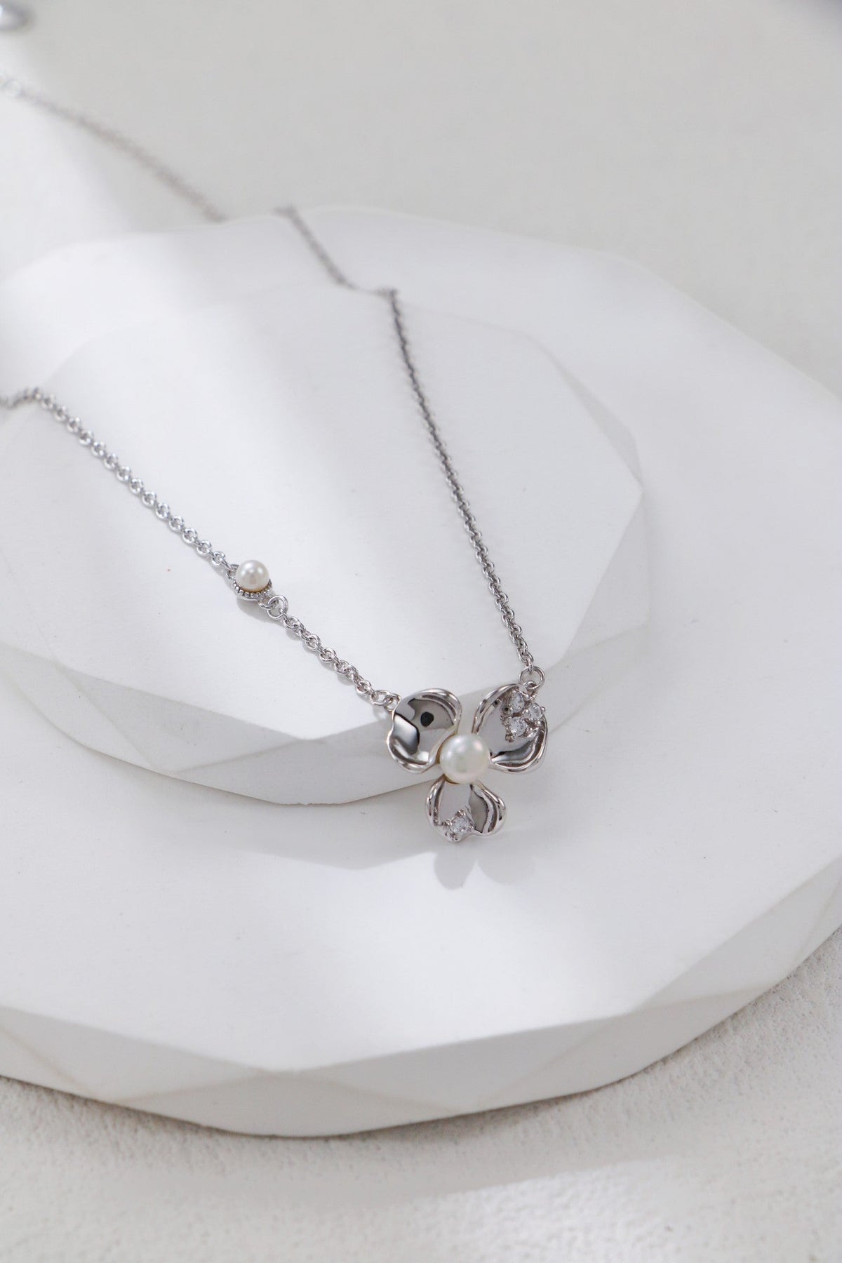 Botanical blossom pendant with pearl centre on a white display block