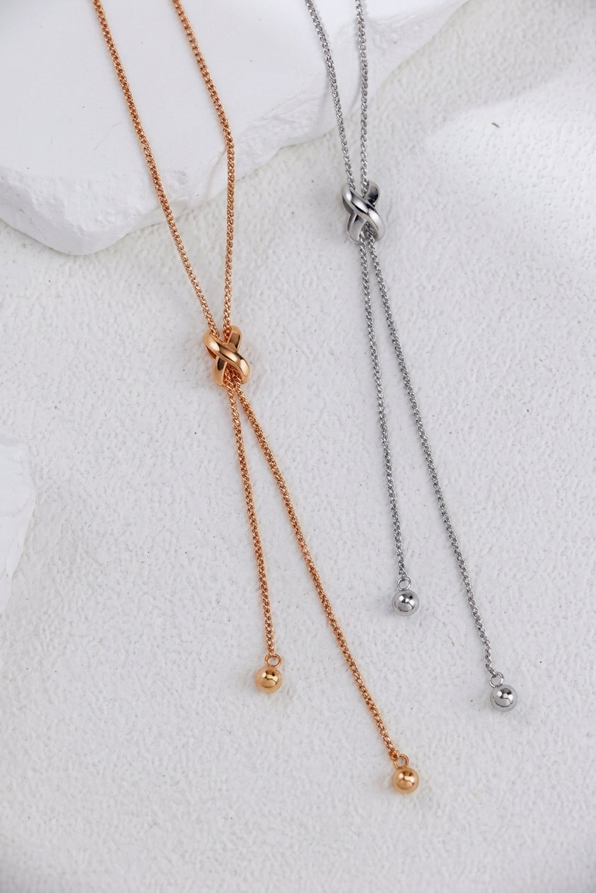 Chinese knot jewelry: the Fashion Tassel Knot Necklace in silver and vintage gold, each fine lariat chain drawn through a sculpted knot with bead-tipped ends